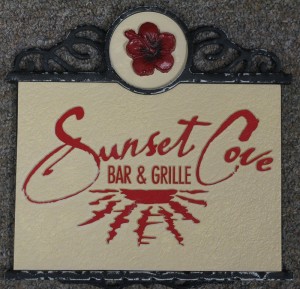 Sunset Cove Bar & Grille sign with flower